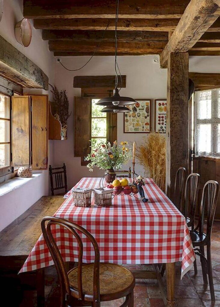 Comedor rústico con mesa de madera, mantel a cuadros rojos y detalles vintage.