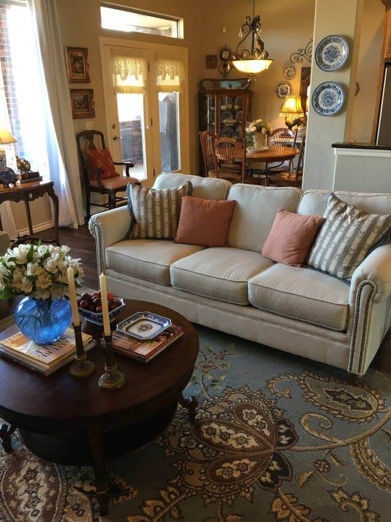 Sala de estar acogedora con sofá beige, mesa de centro y alfombra floral.