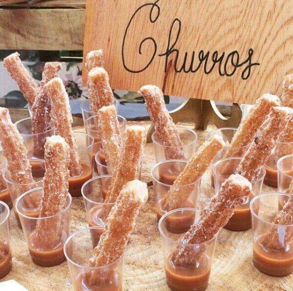 Mini churros en vasos de cristal con dulce de leche, postres para bodas deliciosos y sencillos.