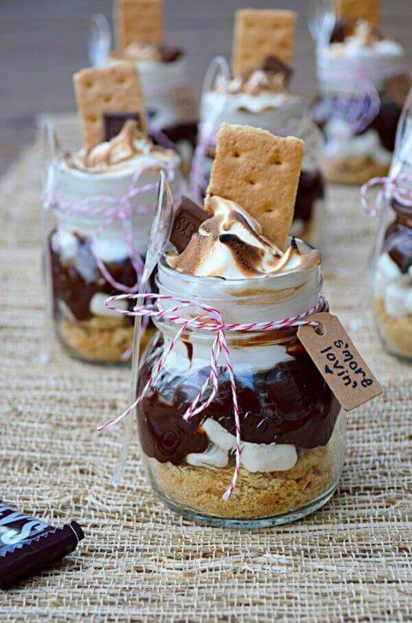 Deliciosos postres de s'mores en tarros de cristal con galletas, chocolate y malvaviscos.