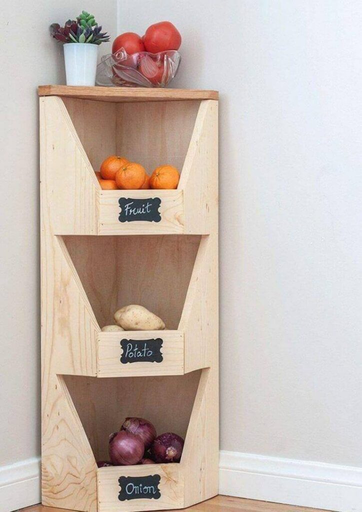 Estantería de madera esquinera con compartimentos para frutas y verduras.