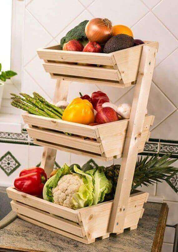 Estantería de madera clara con tres cestas inclinadas para organizar frutas y verduras.