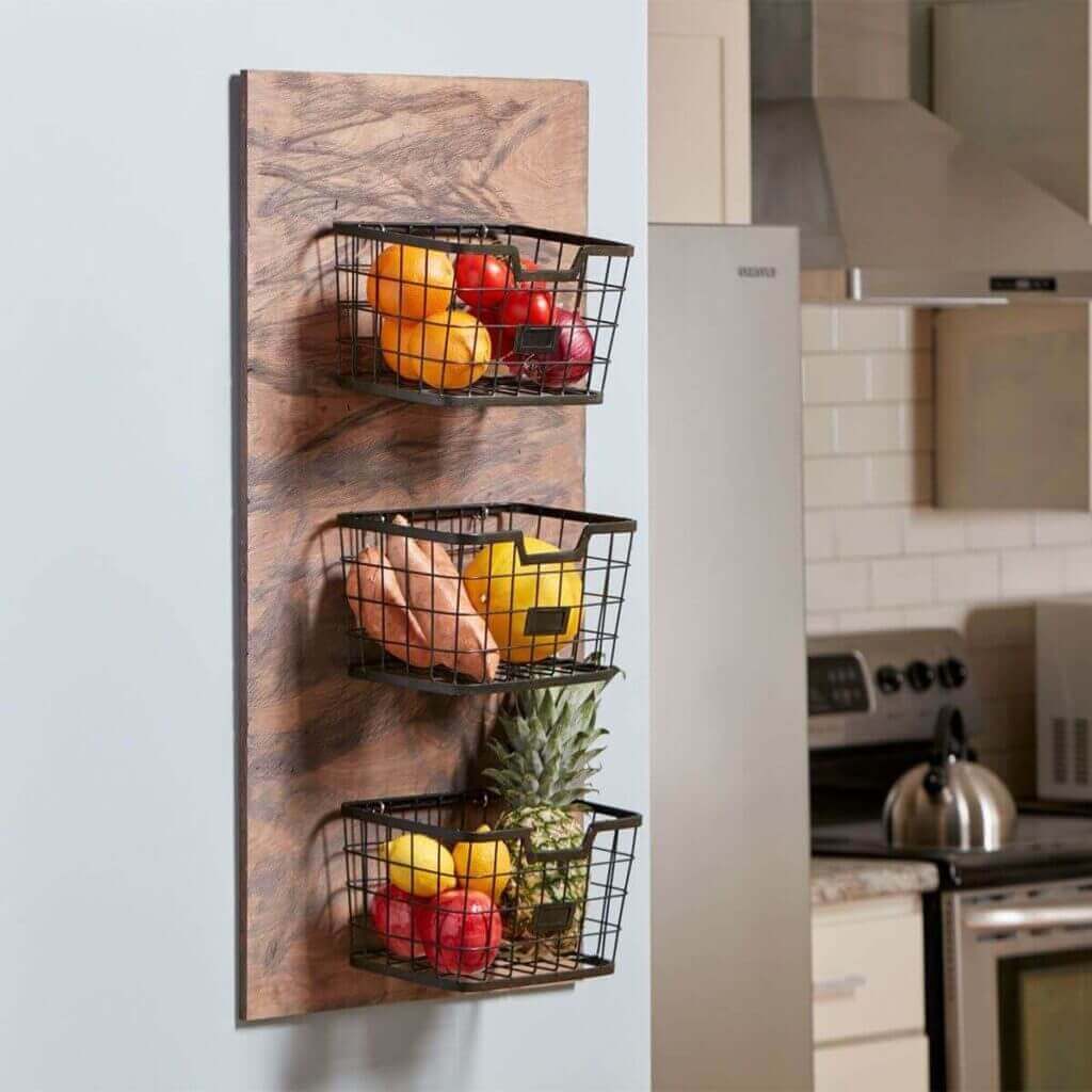 Panel de madera con cestas metálicas, solución decorativa para organizar la fruta en la cocina.
