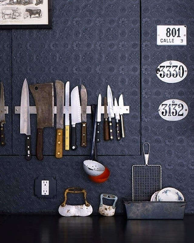 Ideas prácticas para el hogar: Cuchillos imantados sobre fondo oscuro con decoración vintage.