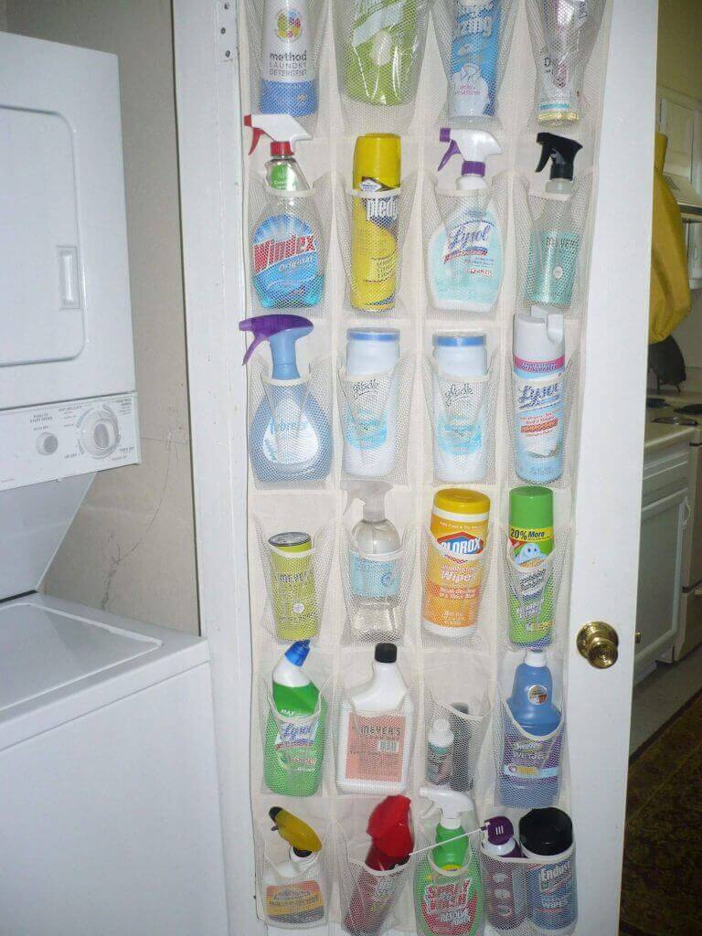 Organizador colgante de tela: Productos de limpieza acomodados en compartimientos con fondo de madera.