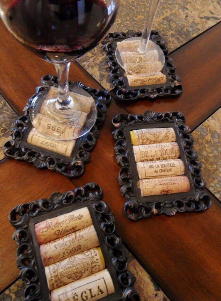 Posavasos decorativos con corchos: Cuatro marcos negros en mesa de madera sostienen tapones de vino reciclados.